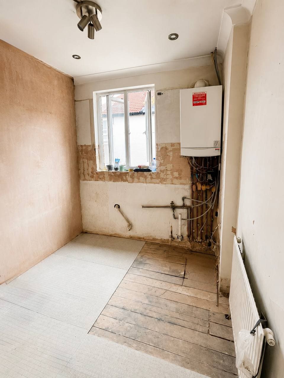 Kitchen space during renovation with stripped wall finishes and exposed services